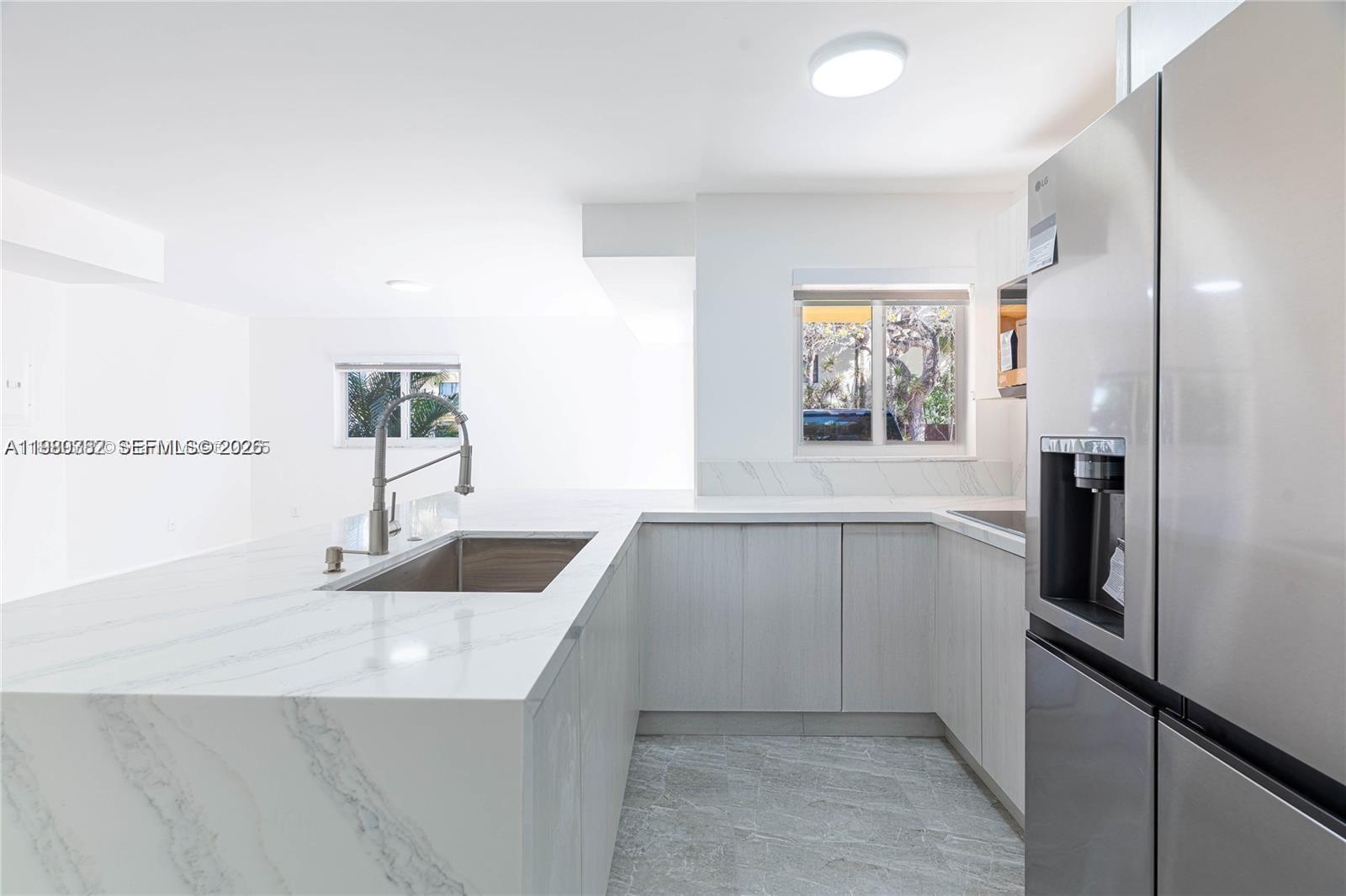 13900 Southwest 65th Terrace, Unit 9 Miami, FL 33183 - Photo 2 of 19 a kitchen with white cabinets and refrigerator