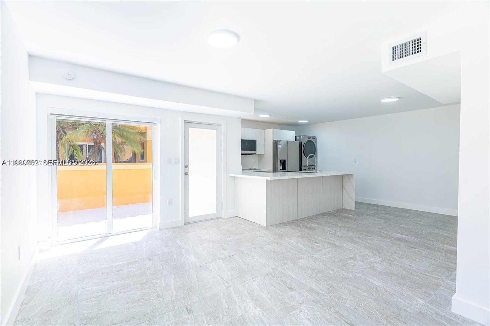 13900 Southwest 65th Terrace, Unit 9 Miami, FL 33183 - Photo 4 of 19 an empty room with a kitchen and a window
