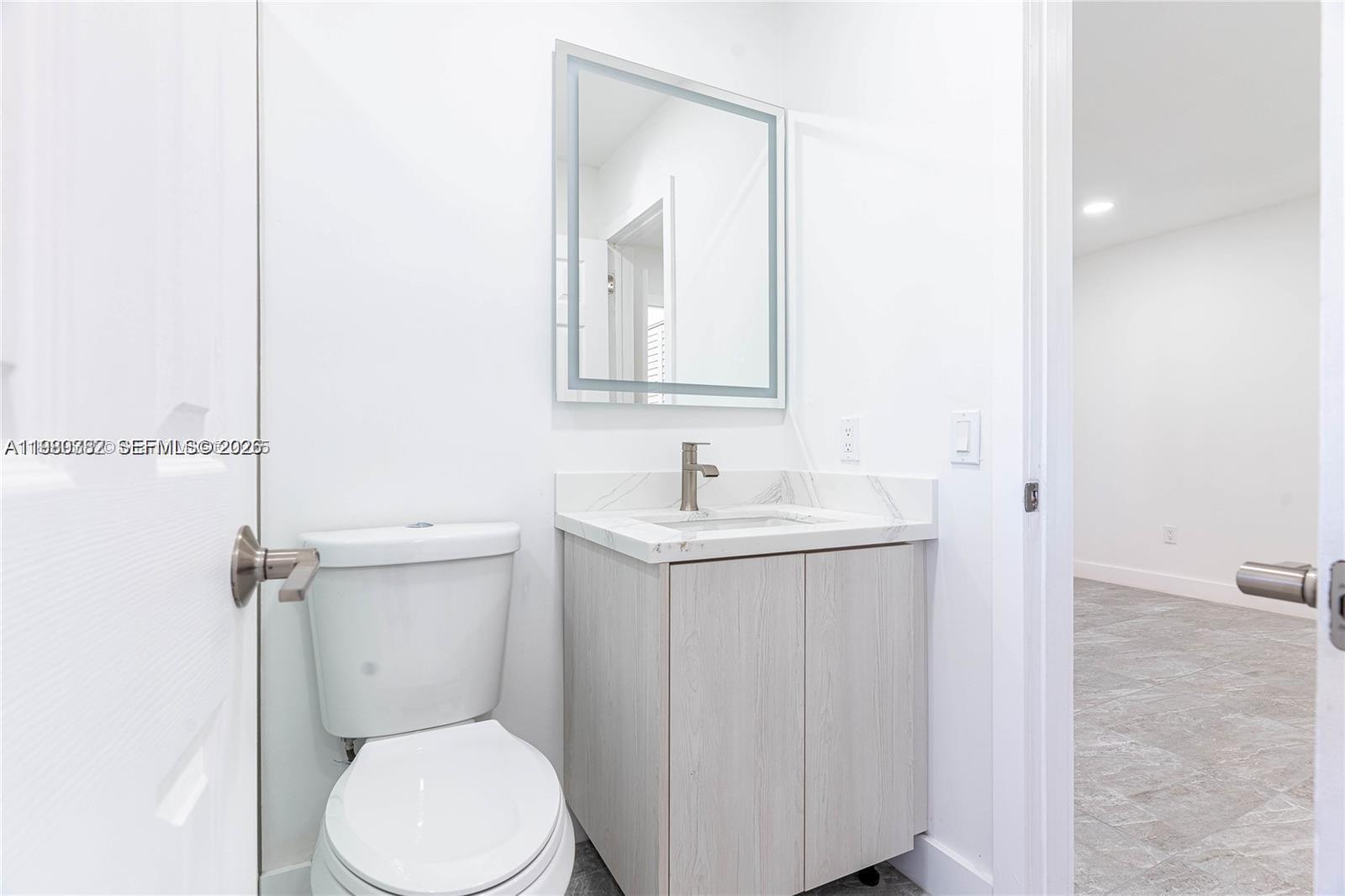 13900 Southwest 65th Terrace, Unit 9 Miami, FL 33183 - Photo 5 of 19 a bathroom with a sink mirror vanity and toilet
