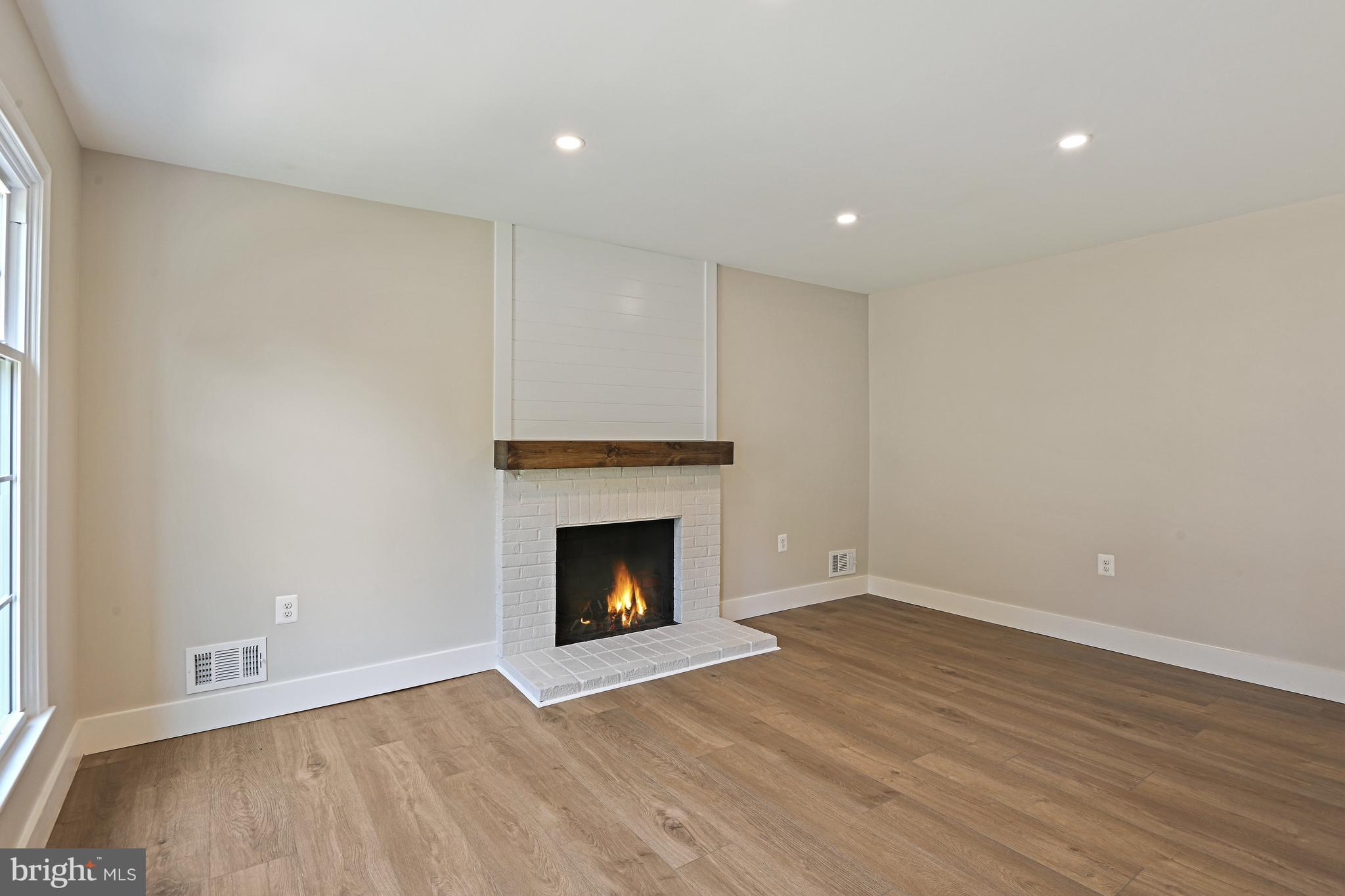 9060 Brook Ford Road Burke, VA 22015 - Photo 17 of 56 a view of an empty room with wooden floor fireplace and a window