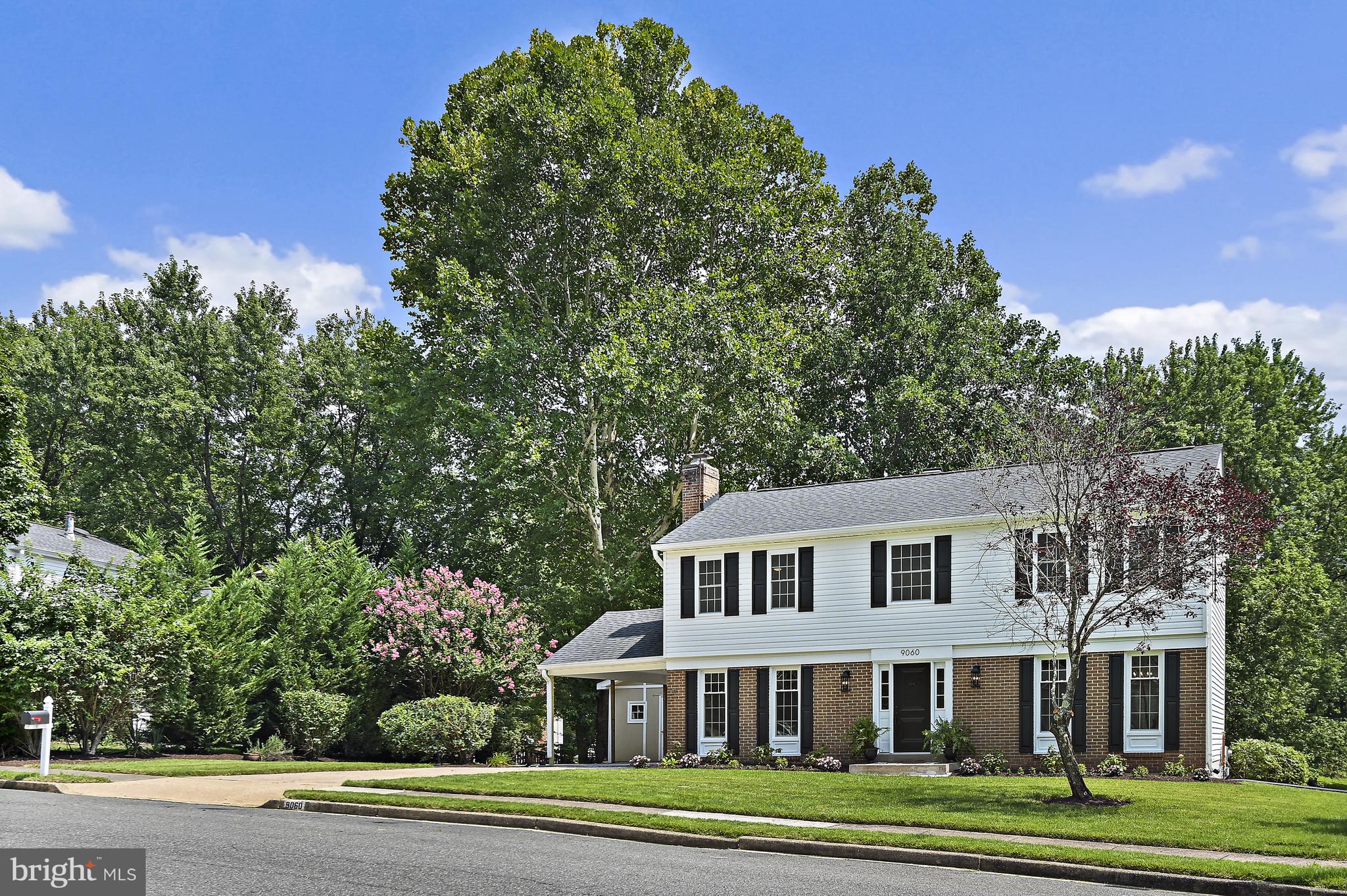 9060 Brook Ford Road Burke, VA 22015 - Photo 52 of 56 a view of a white house with a yard and plants