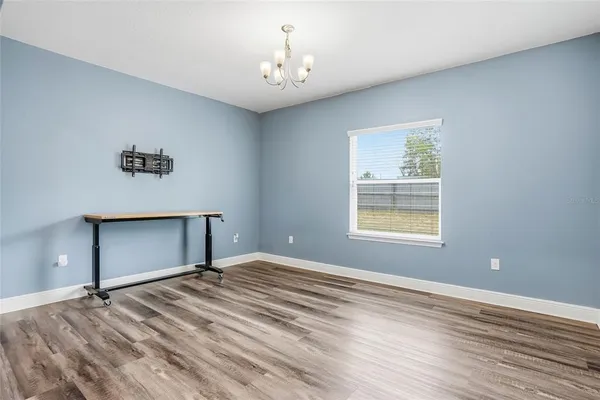 a living room with furniture kitchen view and a wooden floor