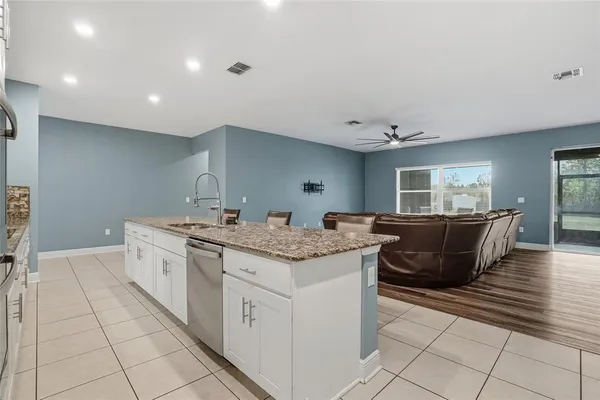 a kitchen with stainless steel appliances granite countertop a sink a stove and a microwave