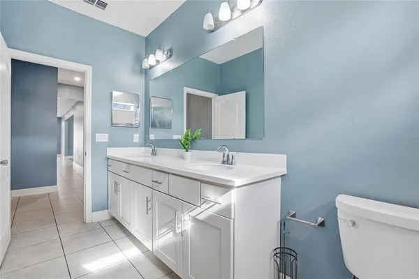 a bathroom with a granite countertop sink a toilet and bathtub