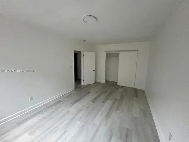 a view of a room with wooden floor and white walls