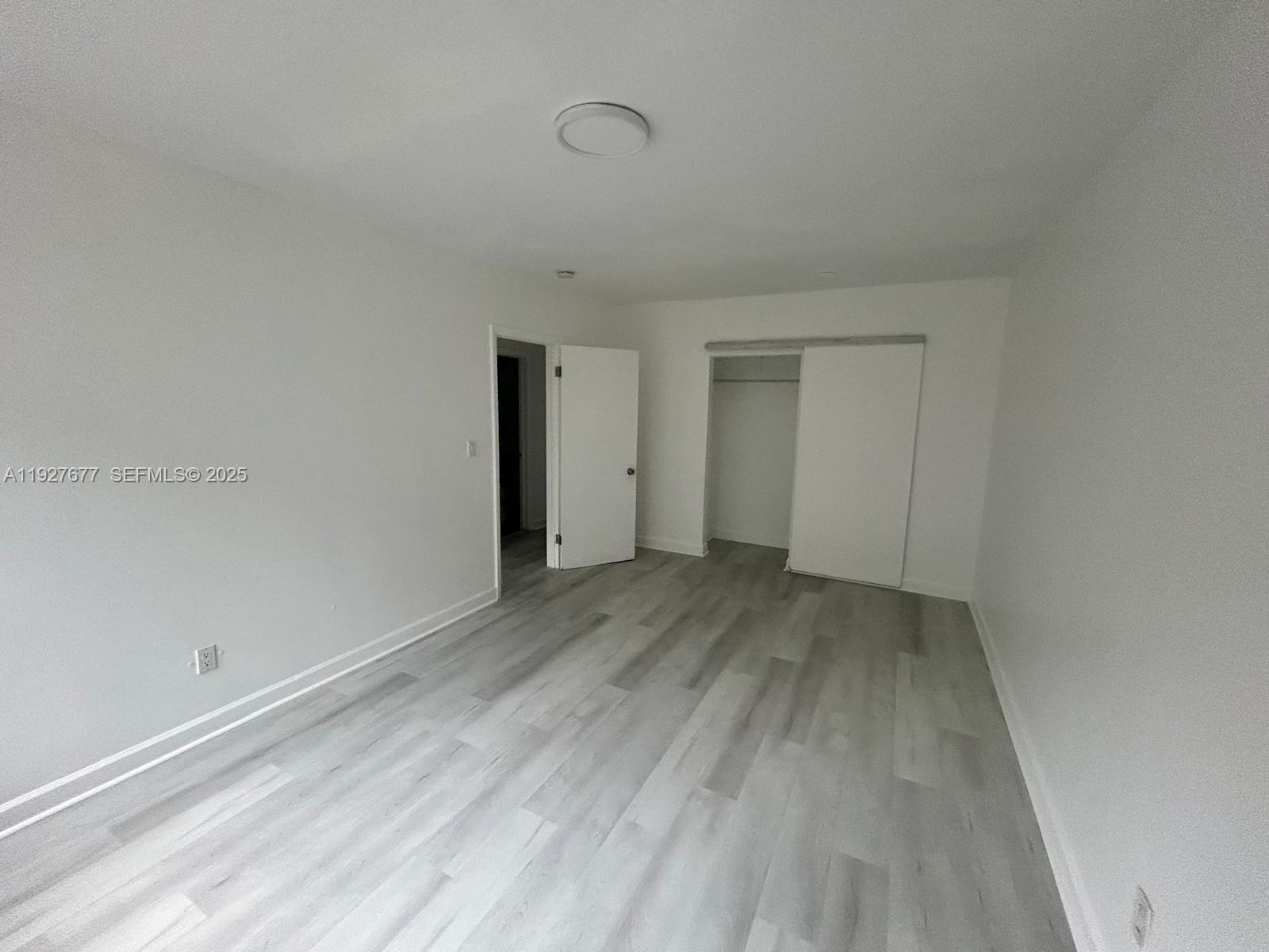 7430 Carlyle Avenue, Unit 2 Miami Beach, FL 33141 - Photo 6 of 8 a view of a room with wooden floor and white walls