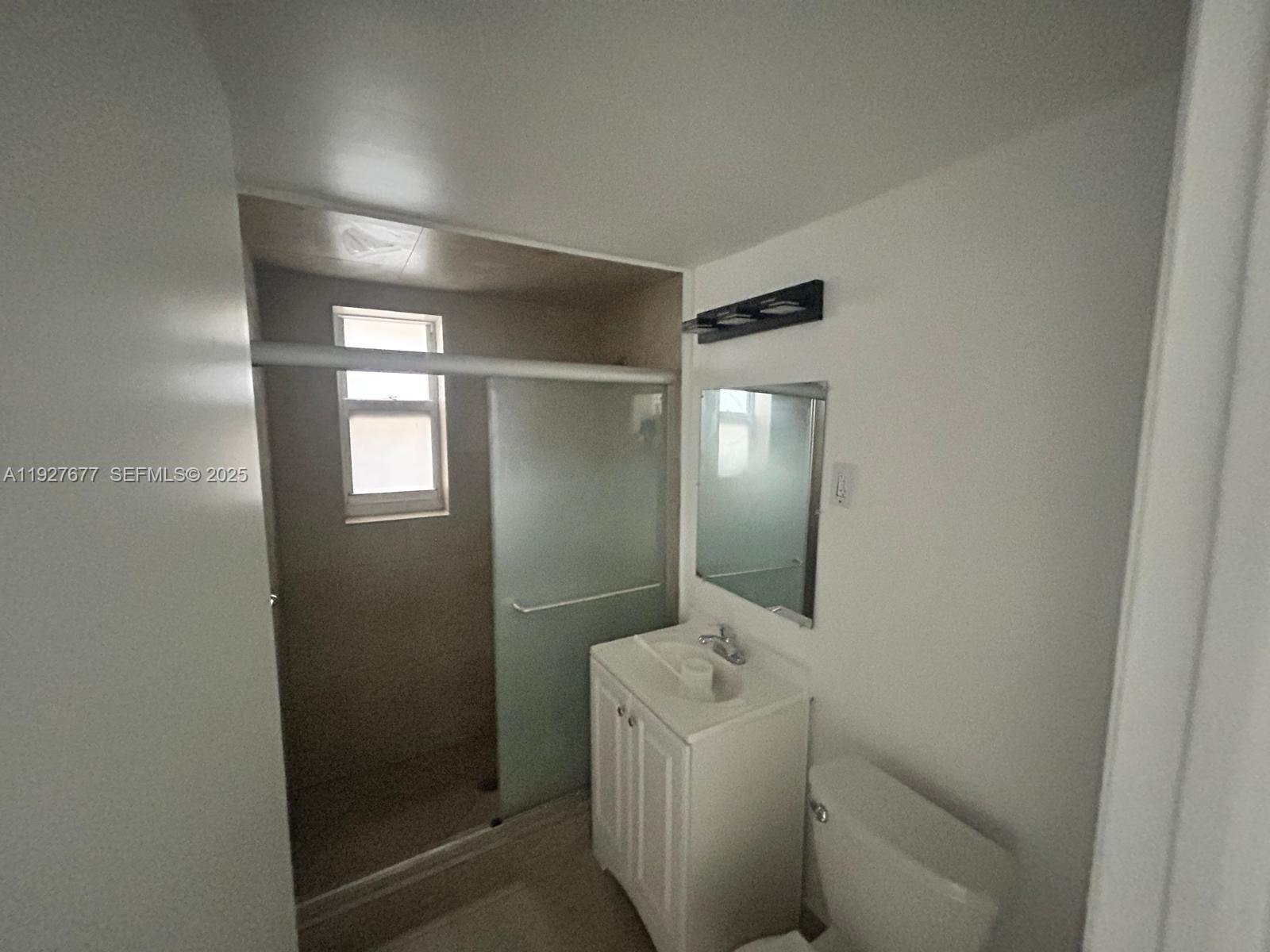 7430 Carlyle Avenue, Unit 2 Miami Beach, FL 33141 - Photo 8 of 8 a bathroom with a sink and mirror