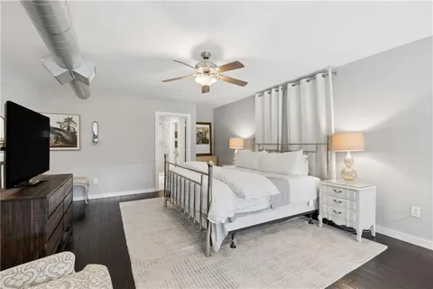 a bedroom with a bed and a flat tv screen on dresser