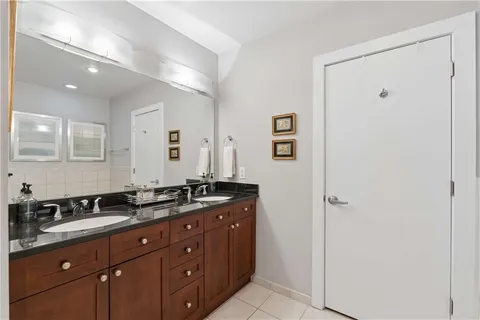 a bathroom with a granite countertop sink a mirror and a shower