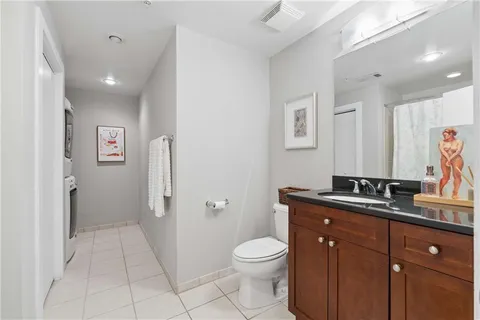 a spacious bathroom with a granite countertop sink a toilet and a mirror