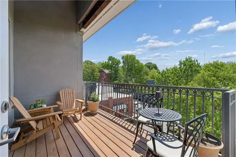 a view of a balcony with wooden floor and outdoor seating