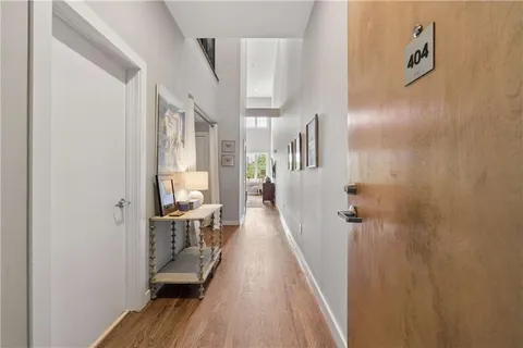 a view of a hallway with wooden floor and staircase
