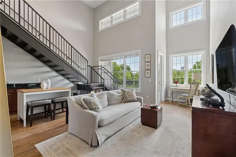 a living room with furniture flat screen tv and a window