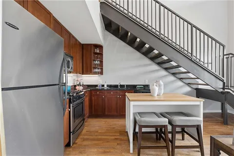a kitchen with a refrigerator a dining table and chairs