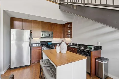 a kitchen with stainless steel appliances granite countertop a refrigerator a stove a sink and a microwave