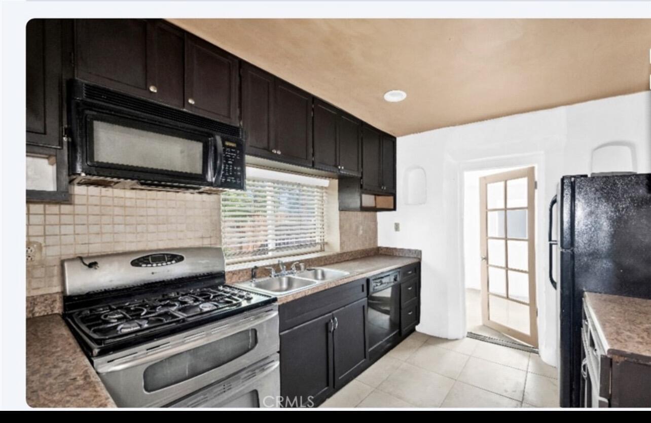82481 Valencia Avenue Indio, CA 92201 - Photo 4 of 13 a kitchen with stainless steel appliances granite countertop a stove and a microwave
