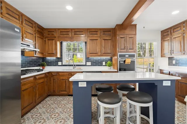 a kitchen with granite countertop a sink chairs and cabinets