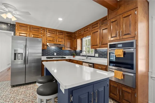a kitchen with stainless steel appliances granite countertop a sink a stove and a refrigerator