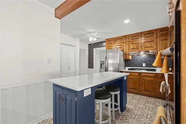 a kitchen with stainless steel appliances granite countertop a sink and a refrigerator