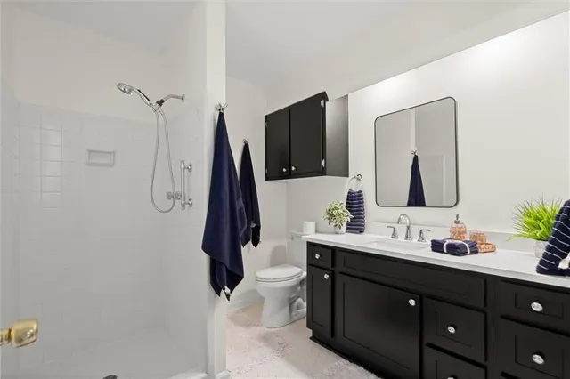 a bathroom with a double vanity sink toilet and mirror