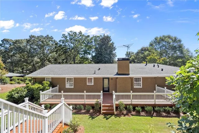 a view of a house with backyard and sitting area
