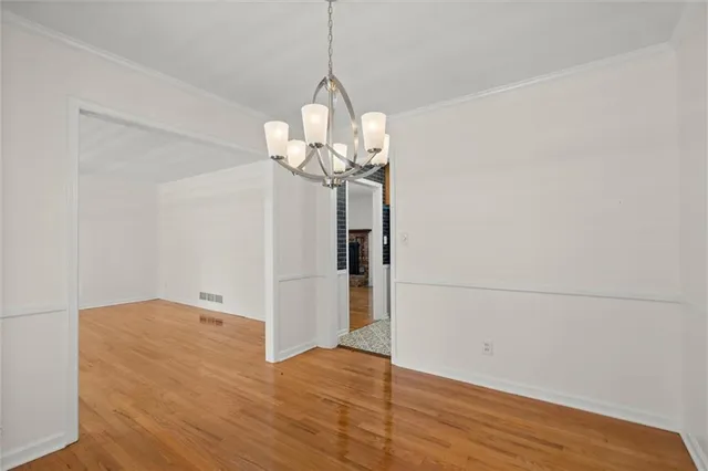 a view of a room with wooden floor and chandelier