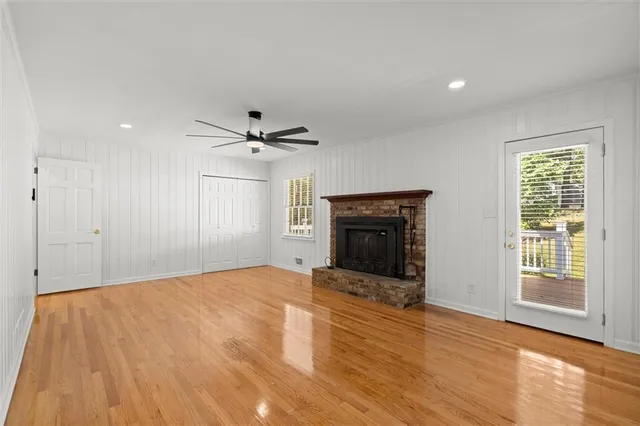 a view of empty room with wooden floor and fireplace