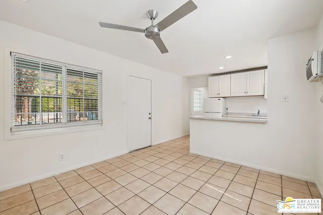 a room view with a ceiling fan and window