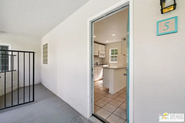 a view of a hallway with a livingroom and a bathroom