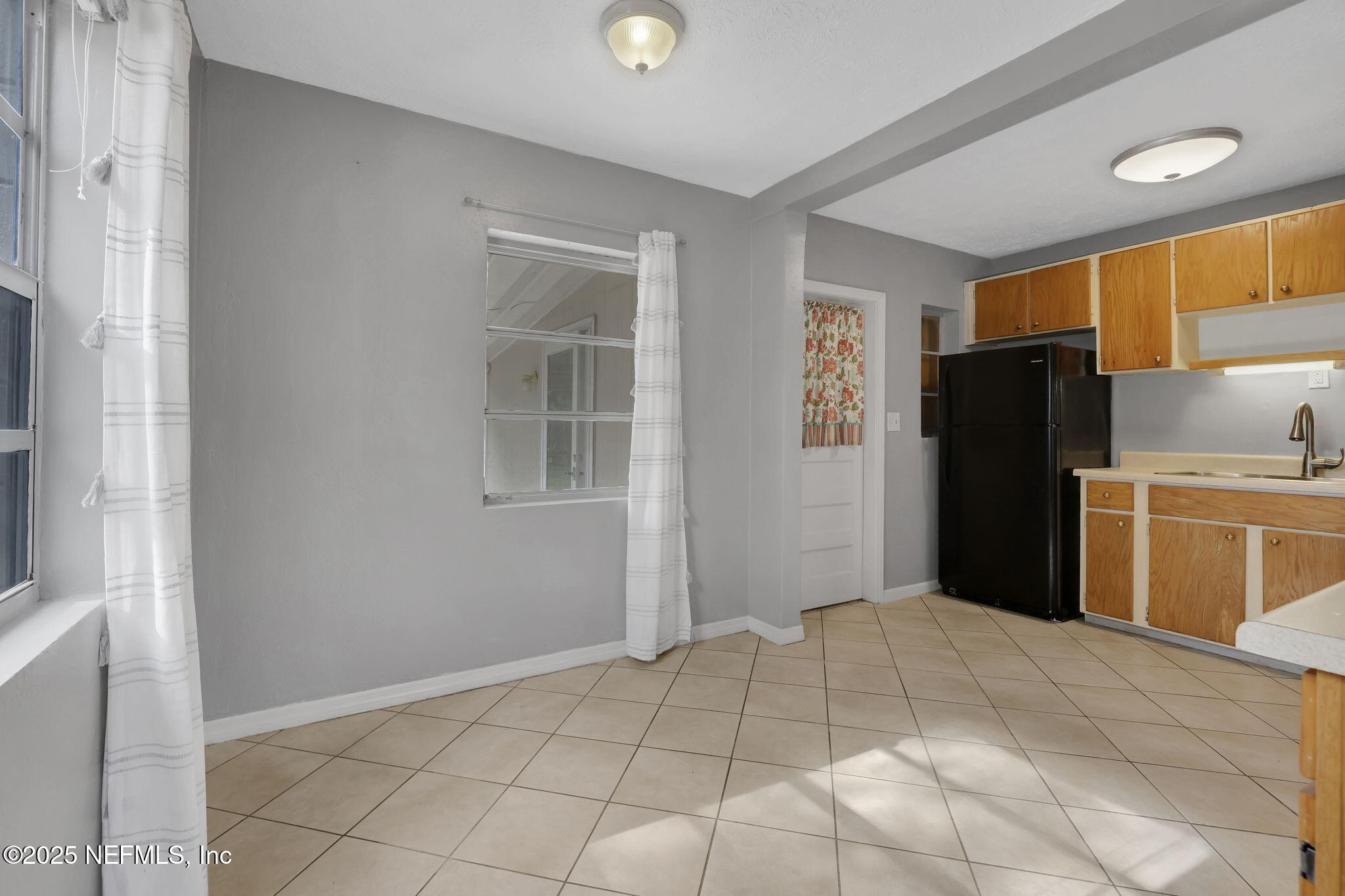 466 Aiken Road Jacksonville, FL 32216 - Photo 12 of 36 a kitchen with a refrigerator cabinet and a refrigerator