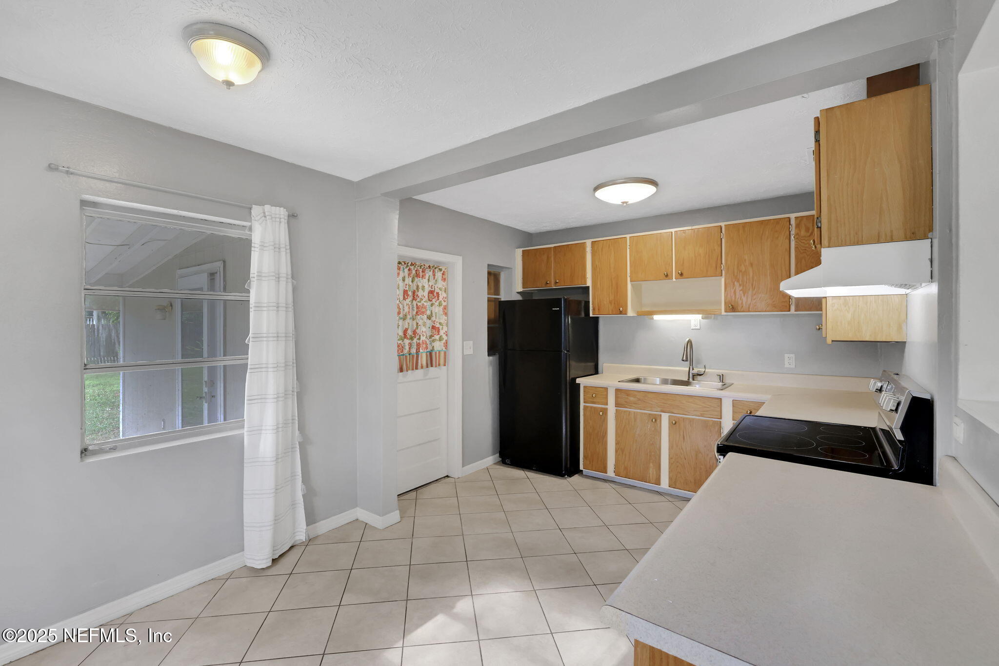 466 Aiken Road Jacksonville, FL 32216 - Photo 13 of 36 a kitchen with a refrigerator and a sink