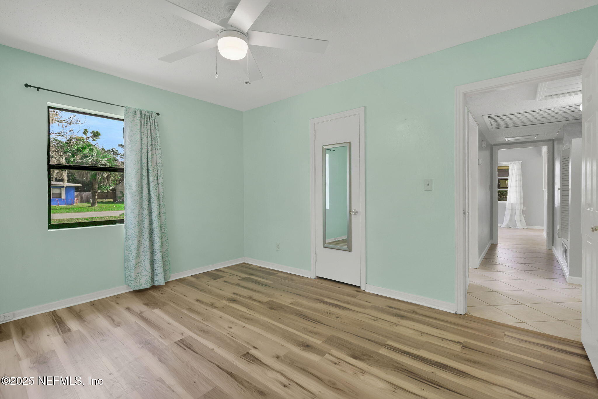 466 Aiken Road Jacksonville, FL 32216 - Photo 19 of 36 a view of a room with wooden floor and a ceiling fan