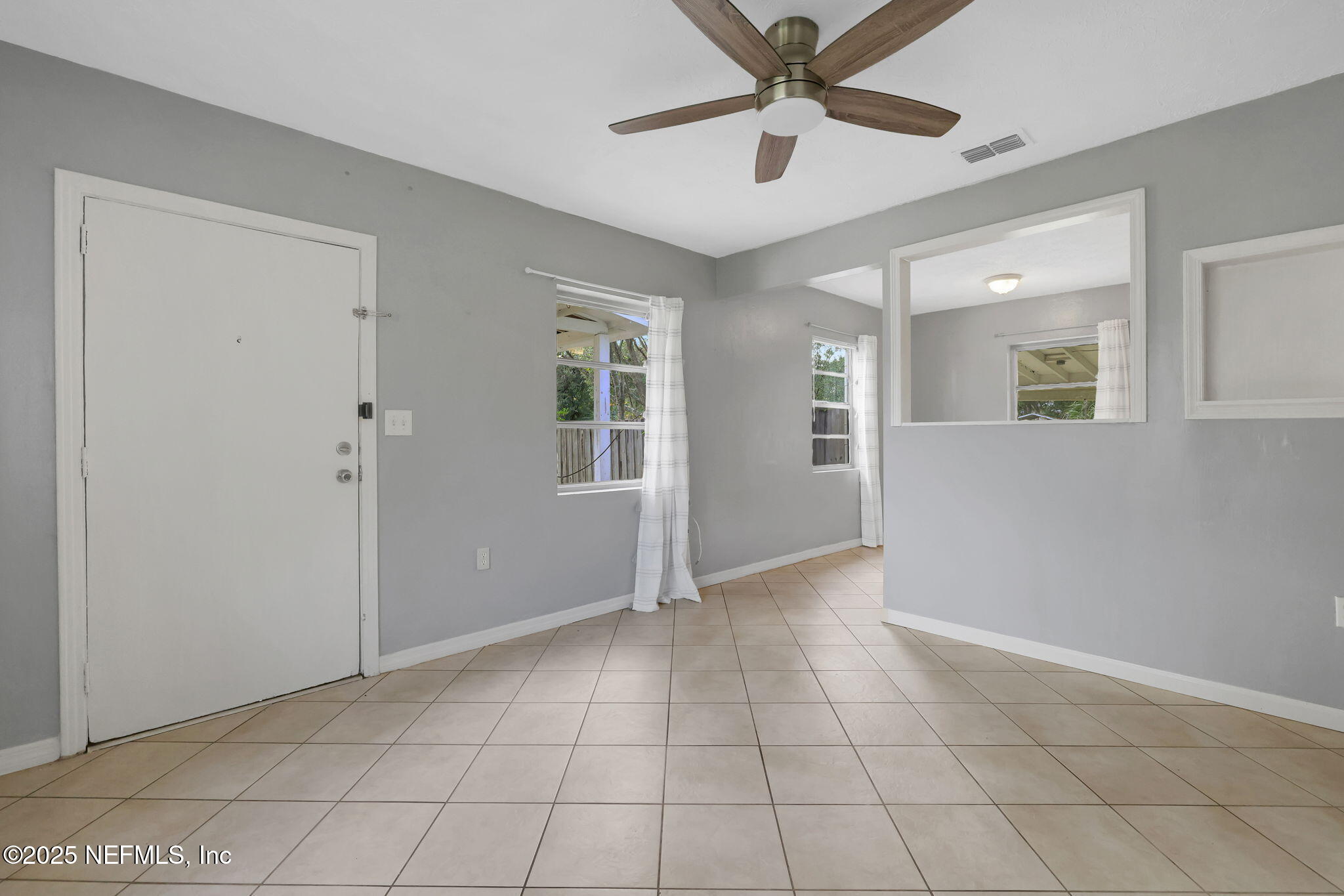 466 Aiken Road Jacksonville, FL 32216 - Photo 9 of 36 a view of an empty room with window and chandelier fan
