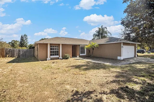 a view of a house with a backyard and a tree