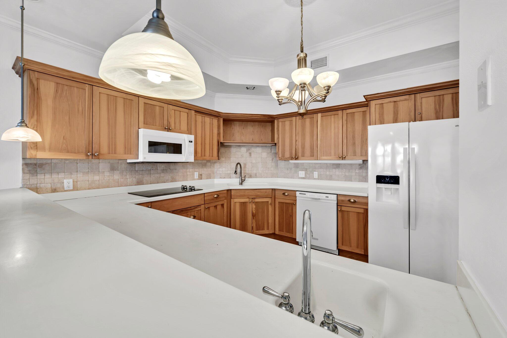 5 Calhoun Avenue, Unit 203 Destin, FL 32541 - Photo 16 of 67 a kitchen with granite countertop a sink cabinets stainless steel appliances and a chandelier