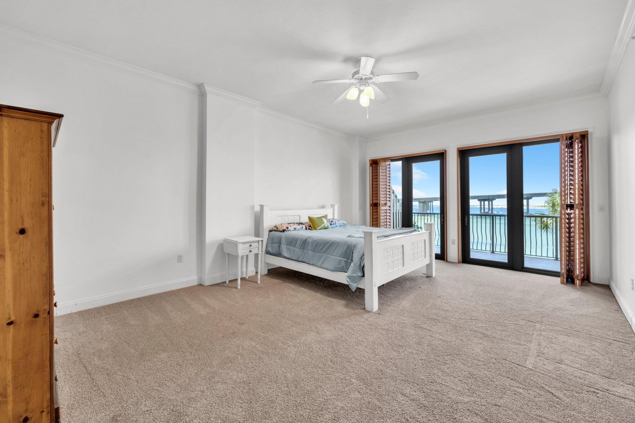 5 Calhoun Avenue, Unit 203 Destin, FL 32541 - Photo 22 of 67 a spacious bedroom with a bed and a chandelier