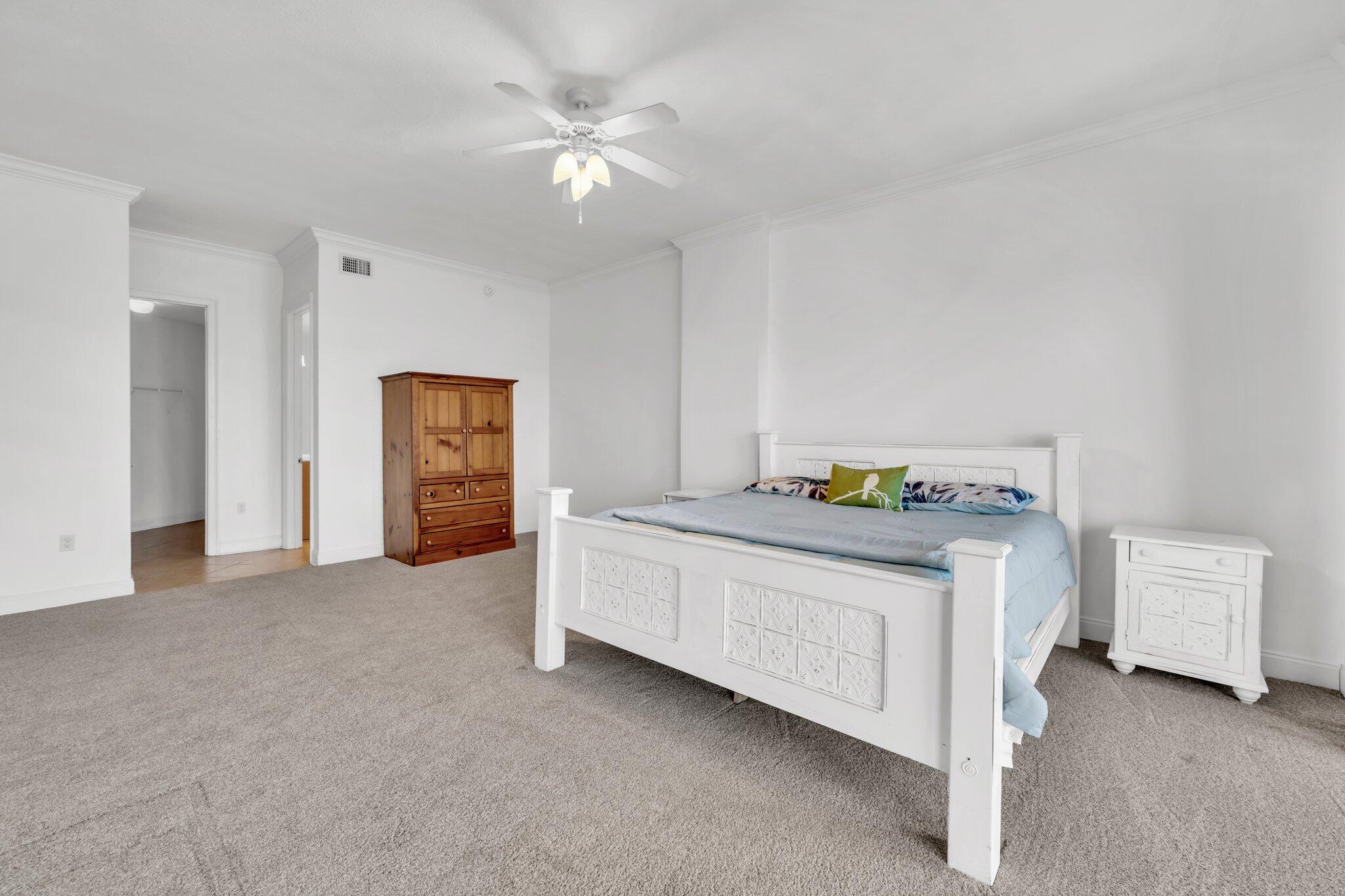 5 Calhoun Avenue, Unit 203 Destin, FL 32541 - Photo 29 of 67 a spacious bedroom with a bed and a table