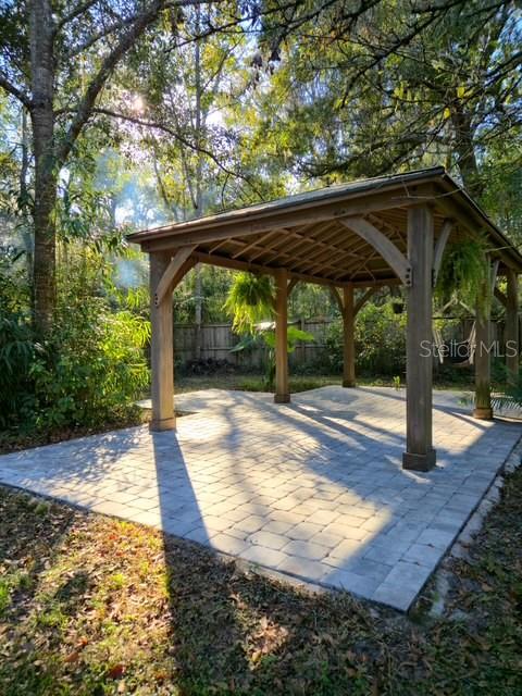 5043 Goodwin Road Brooksville, FL 34601 - Photo 29 of 47 a view of a patio with a table and chairs under an umbrella