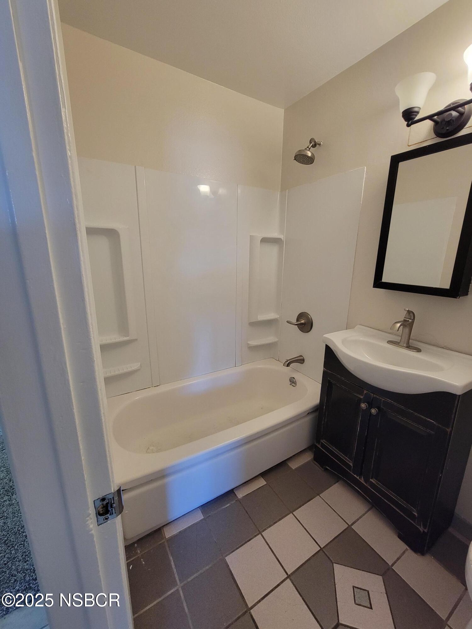 1328 West Willow Avenue Lompoc, CA 93436 - Photo 12 of 22 a bathroom with a bathtub sink vanity and mirror