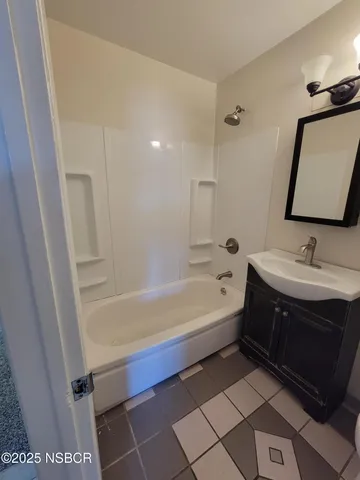 a bathroom with a tub sink and mirror