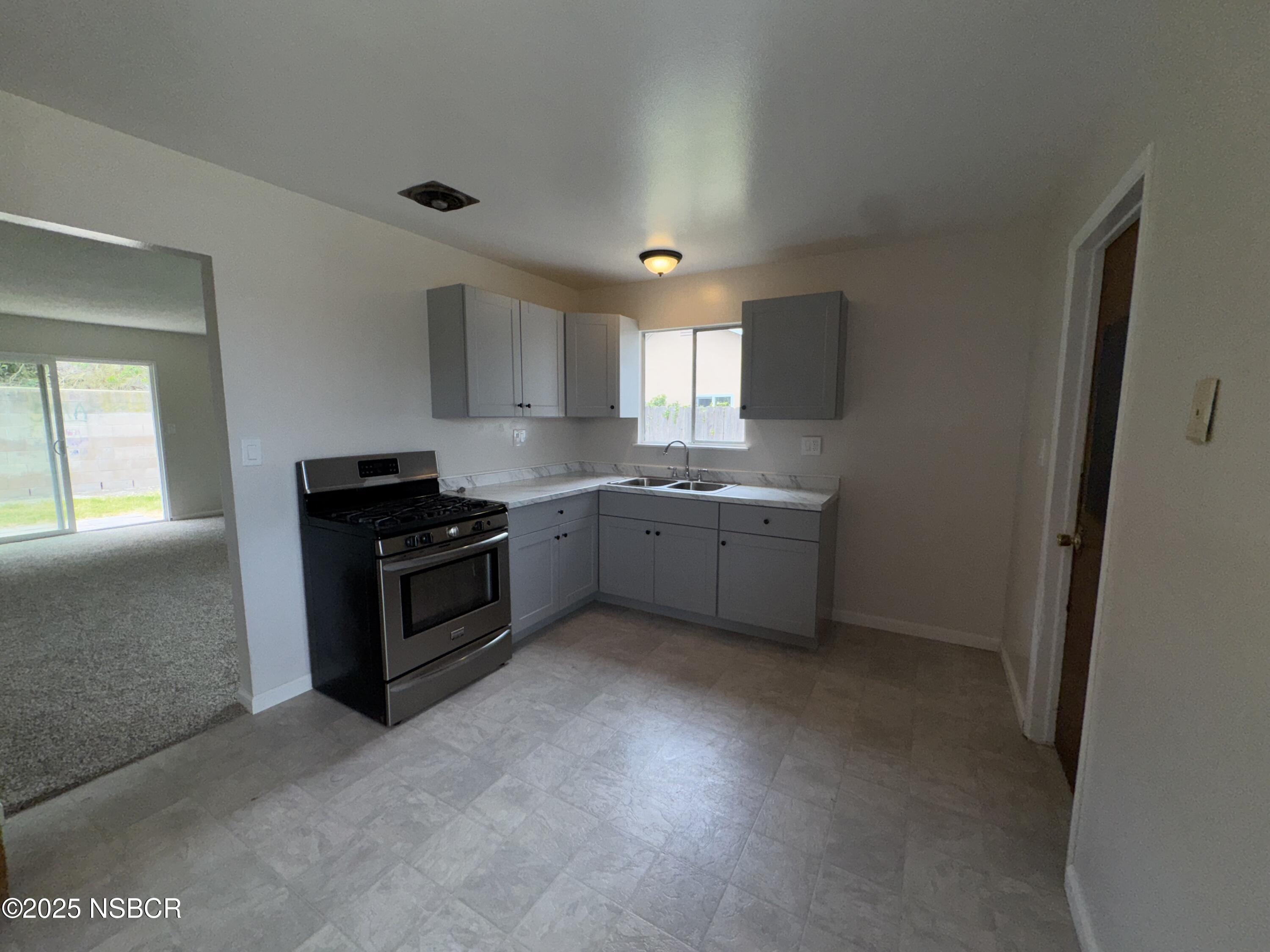 1328 West Willow Avenue Lompoc, CA 93436 - Photo 6 of 22 a kitchen with stainless steel appliances a sink stove and cabinets