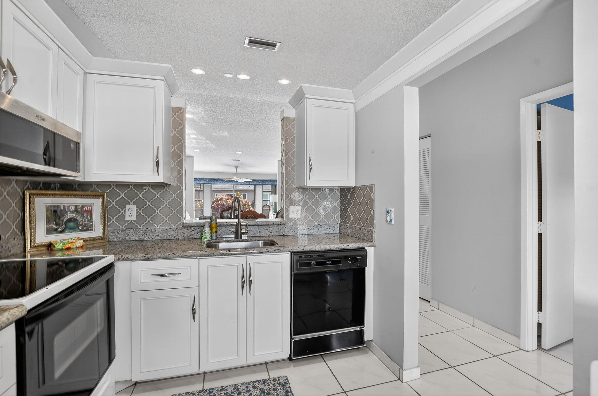 8622 Dreamside Lane Boca Raton, FL 33496 - Photo 6 of 36 a kitchen with stainless steel appliances granite countertop a sink and cabinets