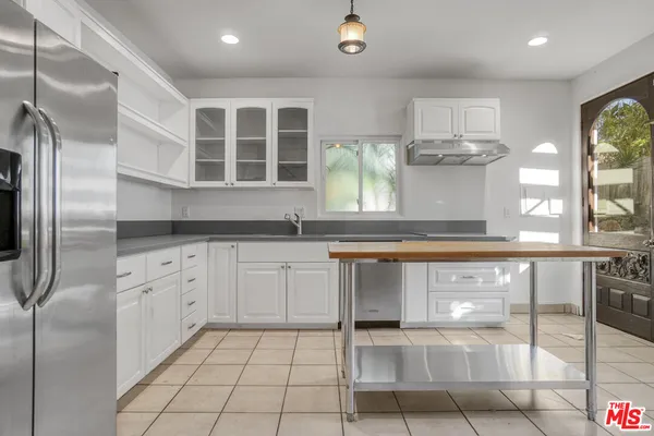 a kitchen with stainless steel appliances granite countertop a refrigerator and a sink