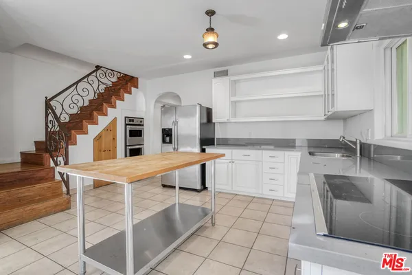 a kitchen with cabinets and chairs