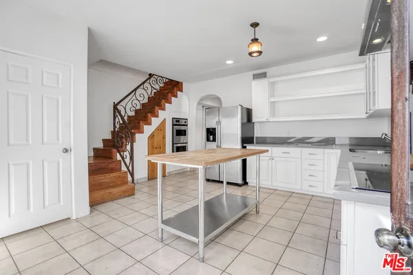 a kitchen with granite countertop a sink cabinets and stainless steel appliances