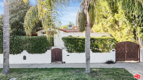 a view of a entrance gate of the house and trees