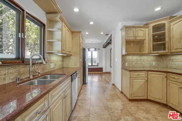 a kitchen with stainless steel appliances granite countertop a sink and a stove