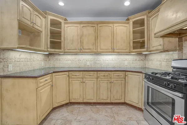 a kitchen with stainless steel appliances granite countertop a sink stove and cabinets