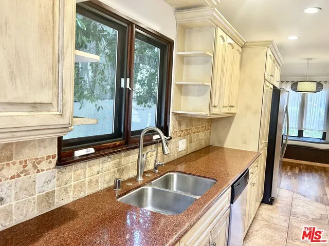 a kitchen with granite countertop white cabinets and sink