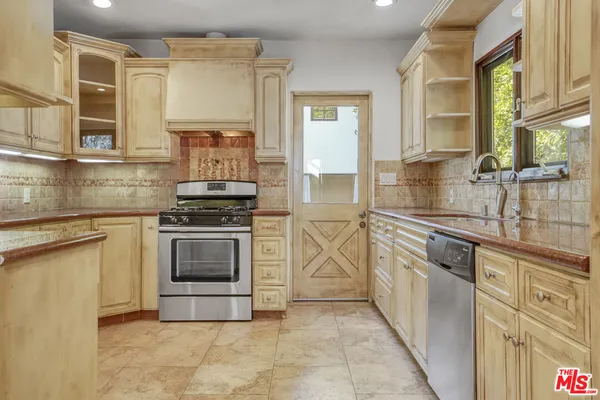 a kitchen with stainless steel appliances granite countertop a stove a sink and a microwave
